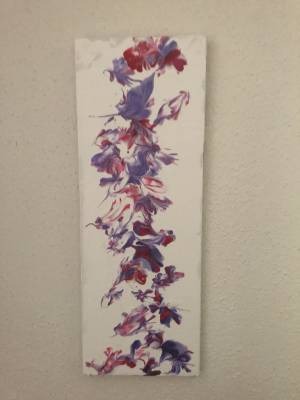 Ein selbstgemaltes längliches Bild mit blumenartigen Mustern in den Farben rot, pink und violett auf weissem Hintergrund.