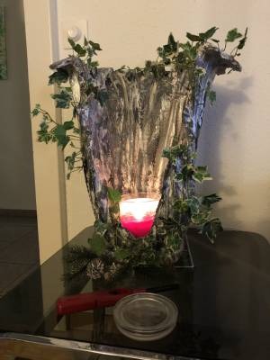 Eine Kerze umwickelt von einer dschungelartigen, silbrigen Wand. Hergestellt aus Gips und Stoff.